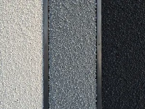 Linear Gravel Design - Straight lines of different colored gravels (white, grey, and black) separated by metal edging, creating strong geometric patterns. Shot from above