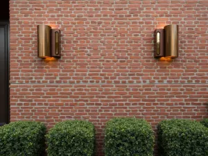 Art Deco Brick Wall Design - A geometric brick wall pattern with art deco influences, featuring copper wall sconces and box hedging