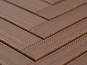 Herringbone Composite Pattern - Close-up detail of a herringbone pattern created with mahogany-toned composite decking boards, showing precise installation and rich color variation