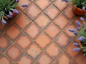 Mediterranean Terracotta Tiles - Warm terracotta tiles in a traditional Mediterranean pattern, close-up view showing weathered texture and natural patina, with potted lavender at the edges