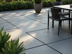 Modern Slate Patio Floor - A modern patio floor with large-format dark slate tiles arranged in a clean, geometric pattern, sunlight casting subtle shadows across the surface, surrounded by minimalist furniture