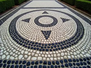 Roman-Style Pebble Mosaic - Wide angle view of a classical Roman-inspired pebble mosaic featuring running border patterns and central medallion in black and white stones