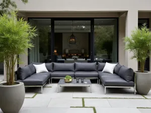 Contemporary Lounge Setting - Sophisticated front patio with modular outdoor sectional in charcoal gray, chrome coffee table, and tall contemporary planters with bamboo, professional architectural photography