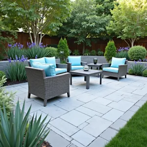 Spring Creek Oasis - Irregular bluestone paver patio with built-in water feature. Japanese iris, dwarf horsetail, and creeping jenny soften the edges. Simple resin wicker furniture in driftwood grey with azure blue cushions.