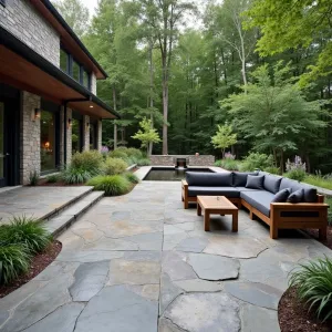 River Rock Fusion Terrace - A stamped concrete patio with embedded river rock patterns creating a naturalistic flow. Weeping Alaska cedar and maiden grass provide vertical interest. Custom concrete water channel with illuminated spillways. Low-profile teak sectional with charcoal cushions and brass accent tables.