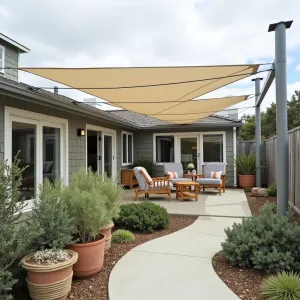 Nautical Canvas Wing Shelter - A maritime-inspired patio cover featuring tensioned sailcloth panels in overlapping wing formations, complete with stainless steel rigging. The coastal garden includes Blue Chalk Sticks, Silver Bush Germander, and Shore Juniper in rope-wrapped containers.