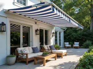 Coastal Retractable Cover - Nautical inspired retractable shade in navy and white stripes, perfect for a coastal style patio with weathered teak furniture